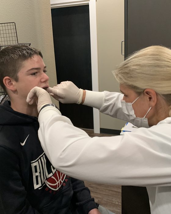 A clinician assessing a patient's jaw muscles during a TMJ evaluation