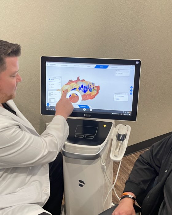 Dr. Beau Sparkman reviewing a 3D scan on screen with an implant patient