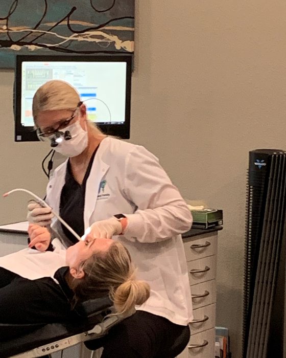 A hygienist reviewing gum health with a patient during a periodontal visit